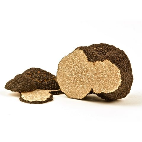 Whole Burgundy Truffle with dark, textured exterior and coffee-colored, veined interior; foraged in Italy and France, known for its earthy hazelnut flavor.