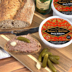 8oz jar of all-natural Duck Rillettes spread on a baguette with cornichons